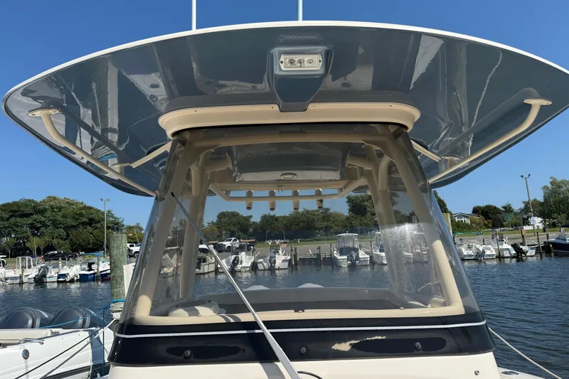 Slide: The Image of 2017 Grady-White Canyon 271 FS boat docked at marina under clear blue sky. - 8
