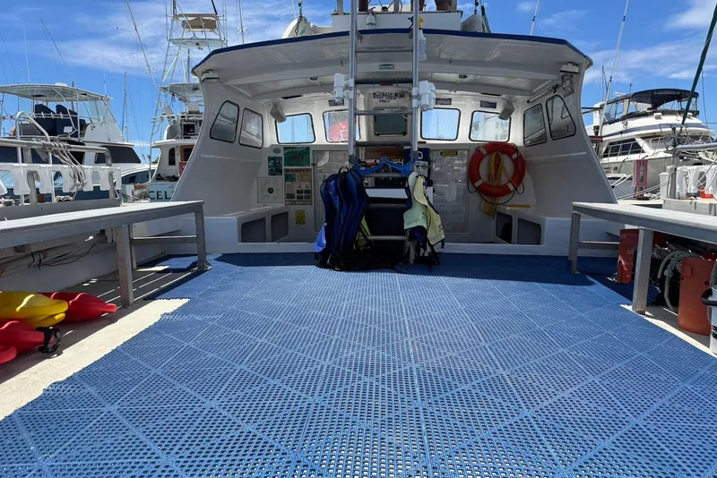 Slide: The Image of 2001 Force Power Cat boat docked, featuring spacious deck and safety equipment. - 10
