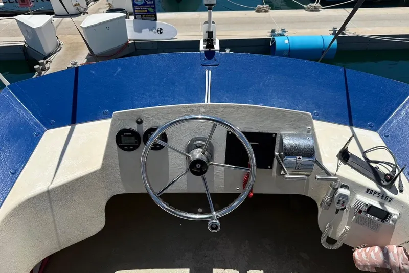 Slide: The Image of 2001 Force Power Cat boat helm with steering wheel and controls at marina. - 9