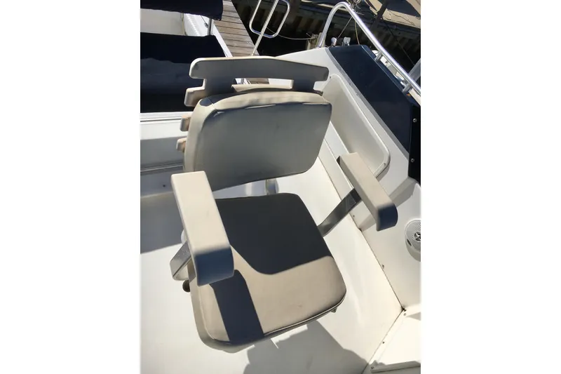 Slide: The Image of Captain's chair on 2000 Phoenix 29 SFX boat, featuring cushioned seat and armrests. - 10