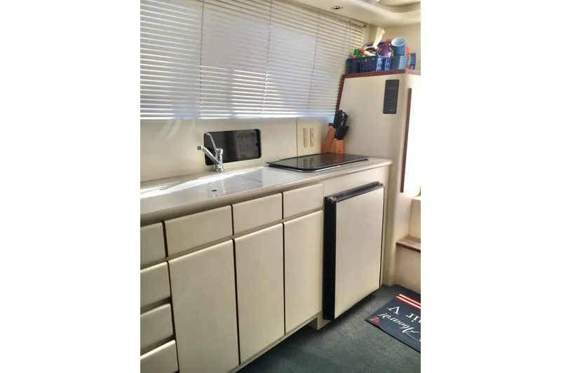 Slide: The Image of Compact kitchen area in a 2000 Phoenix 29 SFX boat with sink and mini fridge. - 22