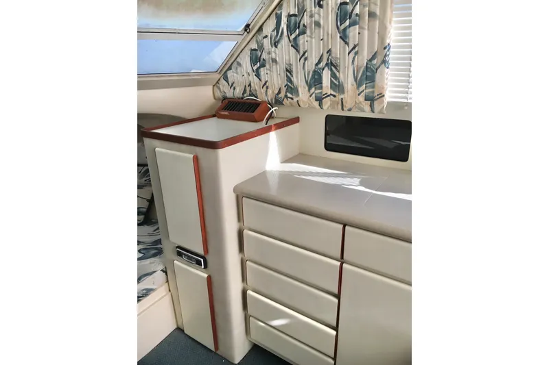 Slide: The Image of Interior of 2000 Phoenix 29 SFX boat with cabinets and patterned curtains. - 23