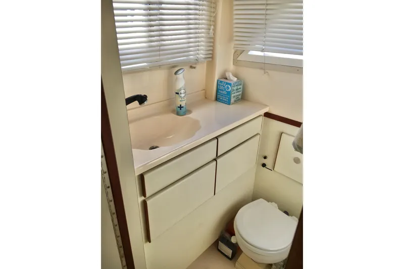 Slide: The Image of Compact bathroom in 2000 Phoenix 29 SFX boat with sink, toilet, and storage. - 24