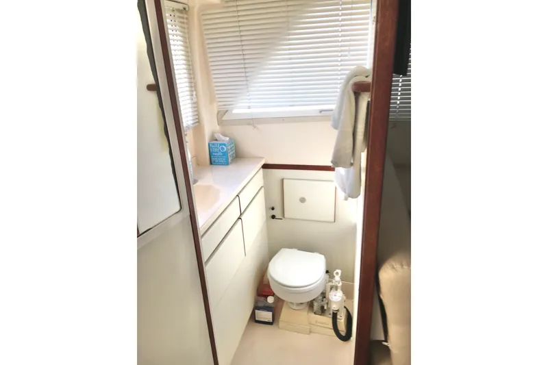 Slide: The Image of Compact bathroom in a 2000 Phoenix 29 SFX boat with toilet and storage. - 25