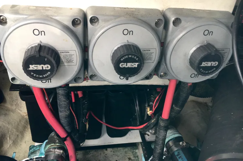 Slide: The Image of Three electrical switches with red cables in a Phoenix 29 SFX boat, 2000 model. - 27