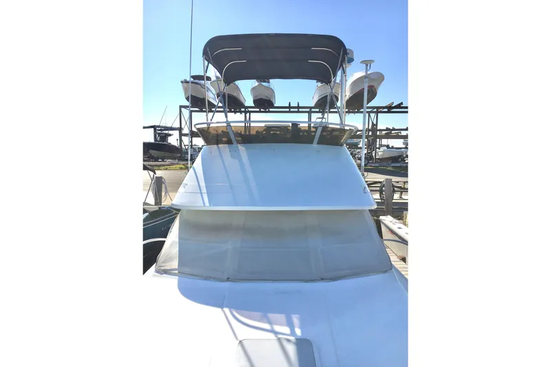 Slide: The Image of 2000 Phoenix 29 SFX boat with canopy, docked under clear blue sky. - 5
