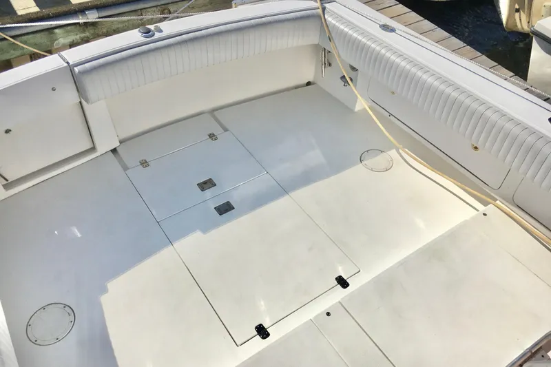 Slide: The Image of Spacious deck of 2000 Phoenix 29 SFX boat with white seating and storage compartments. - 8