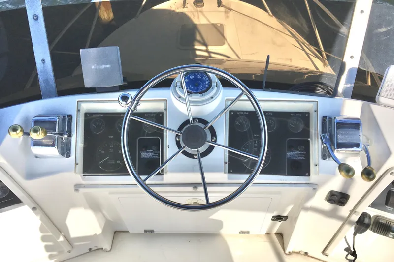 Slide: The Image of Control panel of a 2000 Phoenix 29 SFX boat with steering wheel and gauges. - 9