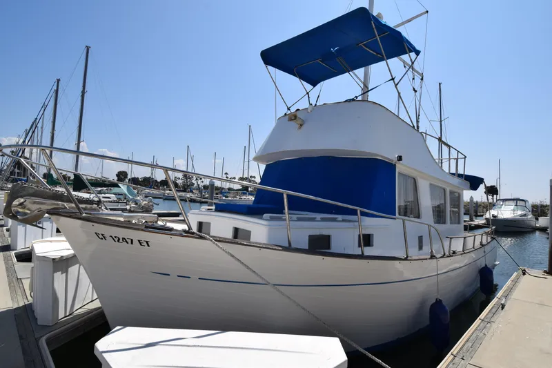 The Image of 1972 CHB 34 boat docked at marina with blue canopy and white hull. - 1