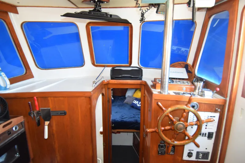 Slide: The Image of 1972 CHB 34 boat interior with wooden helm, navigation equipment, and cozy cabin space. - 12
