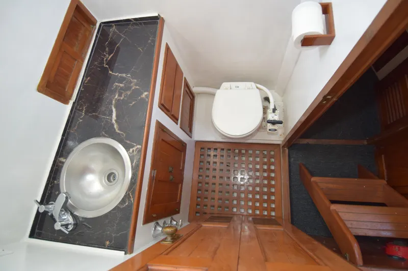 Slide: The Image of 1972 CHB 34 boat bathroom with sink, toilet, and wooden cabinetry. - 14