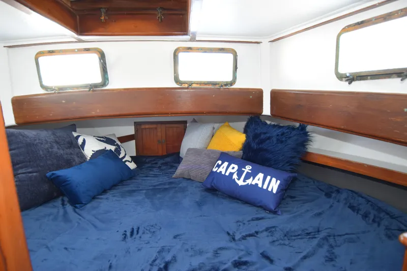 Slide: The Image of Cozy cabin interior of 1972 CHB 34 boat with nautical-themed pillows and wooden accents. - 20