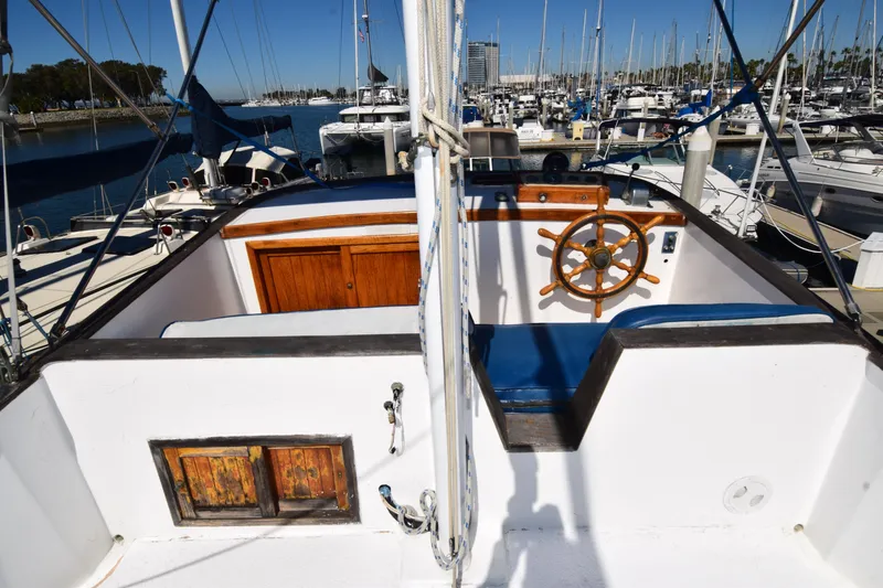 Slide: The Image of 1972 CHB 34 boat cockpit with wooden wheel, docked in a marina. - 27