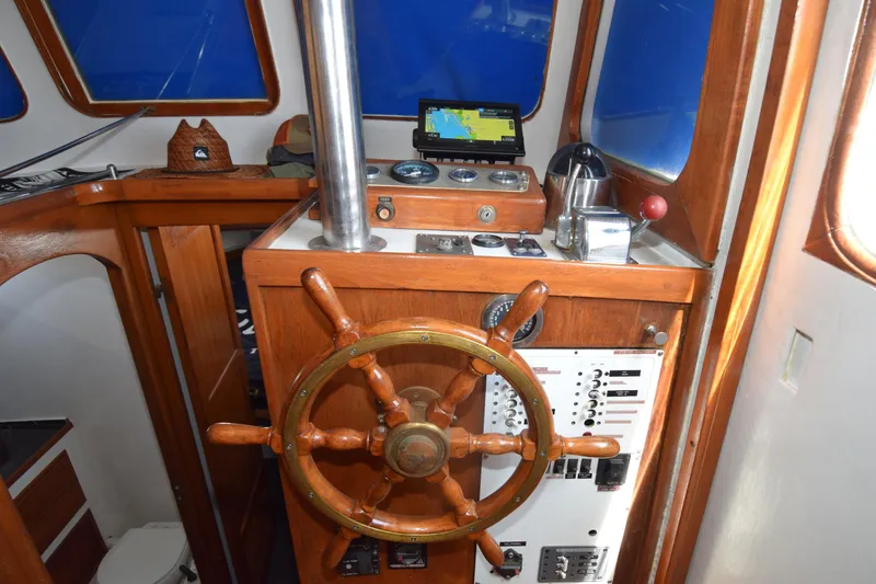 Slide: The Image of 1972 CHB 34 boat helm with wooden wheel, navigation instruments, and control panel. - 8