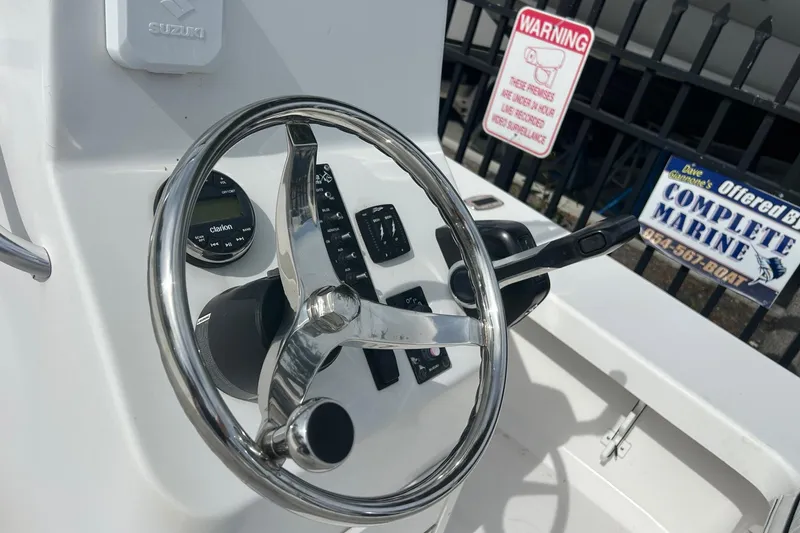 Slide: The Image of Steering console of 2025 Piranha Magro P180 boat with controls and warning sign. - 8