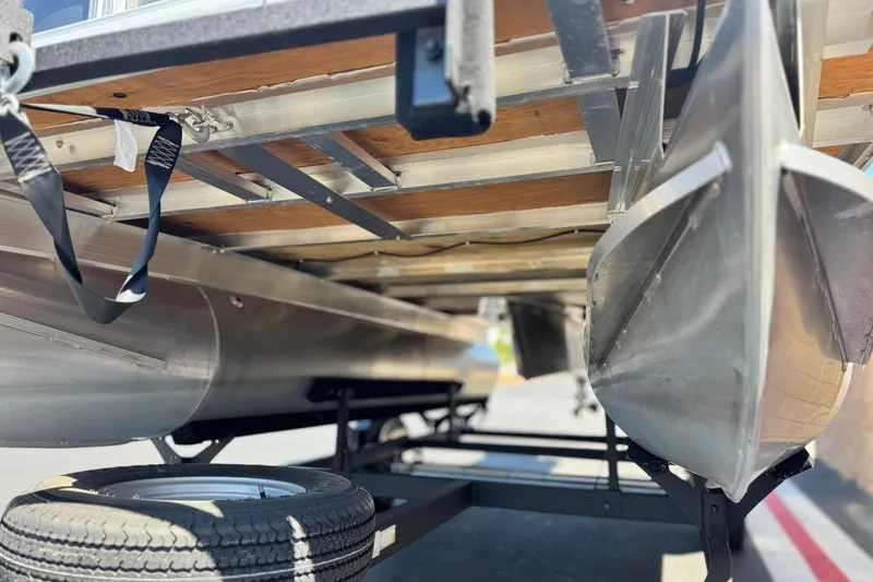 Slide: The Image of Underneath view of 2025 Sun Tracker Party Barge 16 DLX pontoon boat on trailer. - 4