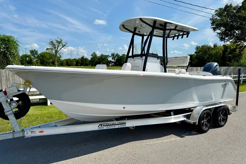 The Image of 2026 Sea Hunt Ultra 229 boat on trailer, parked outdoors under a clear blue sky. - 1