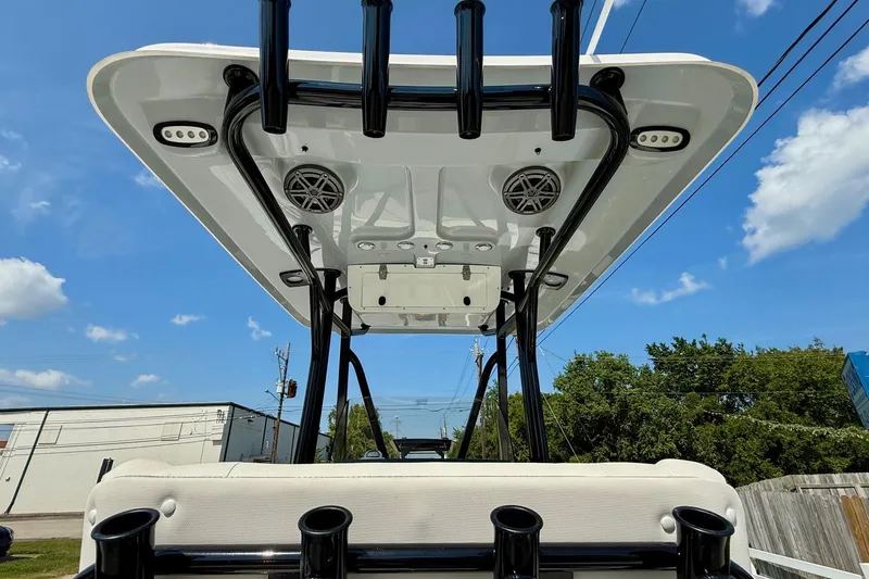Slide: The Image of 2026 Sea Hunt Ultra 229 boat with T-top and rod holders under a clear sky. - 11