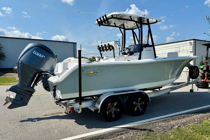Slide: The Image of 2026 Sea Hunt Ultra 229 boat on trailer with Yamaha outboard motor, parked outdoors. - 4