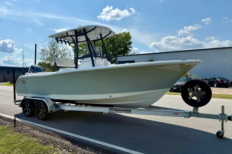 Slide: The Image of 2026 Sea Hunt Ultra 229 boat on trailer, parked outdoors under a clear sky. - 5