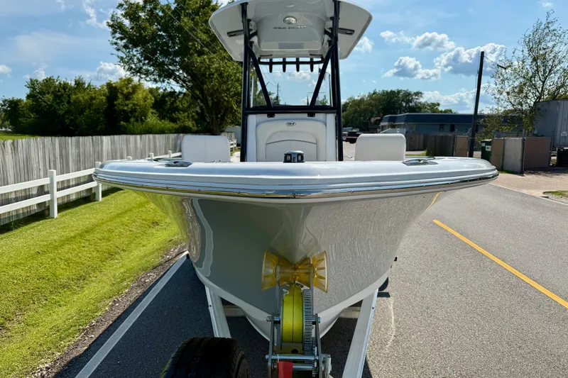 Slide: The Image of 2026 Sea Hunt Ultra 229 boat on trailer, parked on a sunny road. - 6