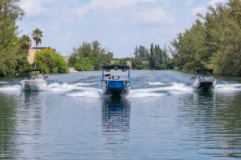 Slide: The Image of 2026 Nautique Super Air Nautique G23 boats cruising on a scenic waterway. - 24