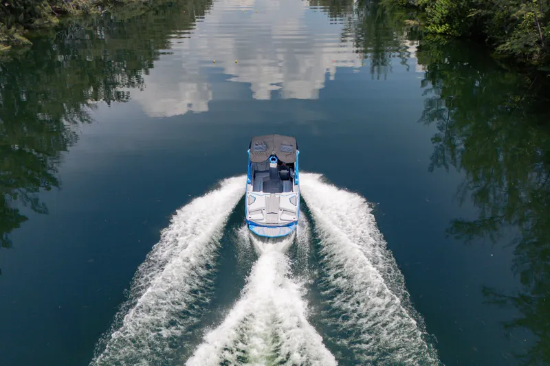 Slide: The Image of 2026 Nautique Super Air Nautique G23 cruising on a serene lake. - 27