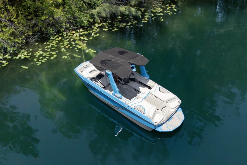 Slide: The Image of 2026 Nautique Super Air Nautique G23 boat on serene water surrounded by greenery. - 31
