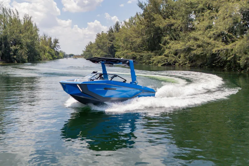 Slide: The Image of 2026 Nautique Super Air Nautique G23 boat cruising on a scenic waterway. - 35