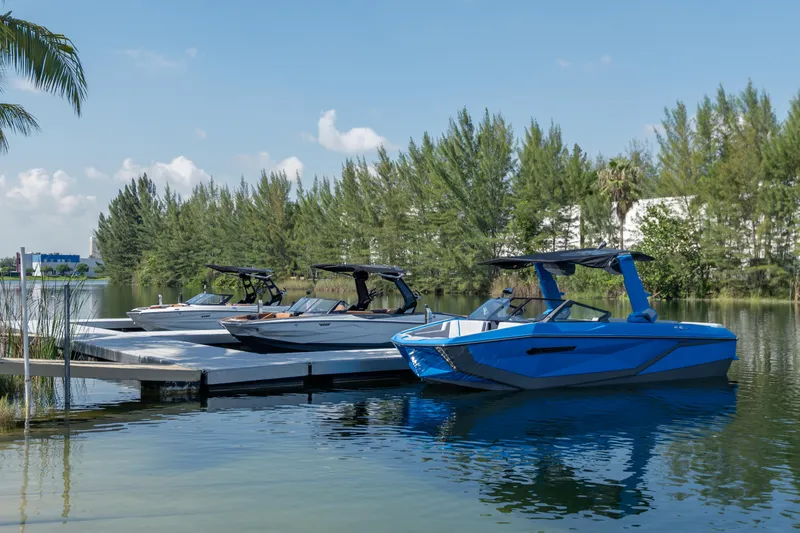 Slide: The Image of 2026 Nautique Super Air Nautique G23 boats docked on a serene lake. - 41
