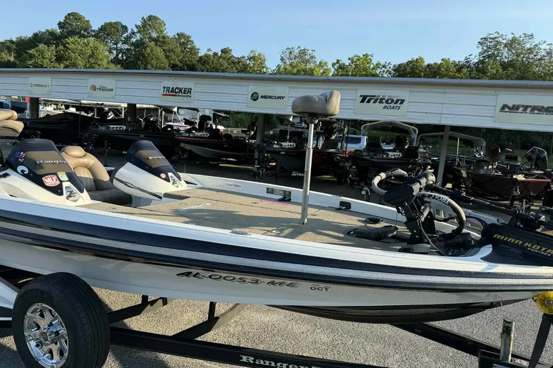 The Image of 2012 Ranger Z521 Comanche boat on trailer, parked at dealership with other boats. - 1