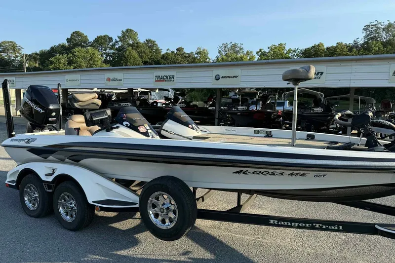Slide: The Image of 2012 Ranger Z521 Comanche boat with Mercury engine on trailer, parked outdoors. - 2