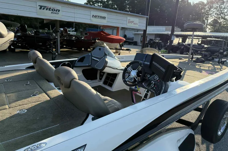 Slide: The Image of 2012 Ranger Z521 Comanche boat interior with steering console and seats at a dealership. - 3