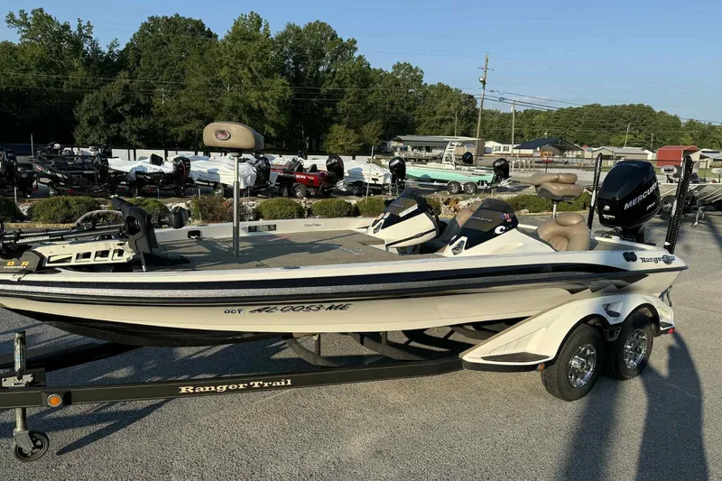 Slide: The Image of 2012 Ranger Z521 Comanche boat on trailer, parked outdoors with trees in background. - 8