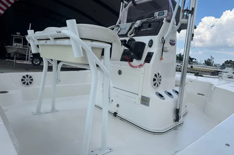 Slide: The Image of 2019 Epic E2 2100 Bay boat interior with console and seating, docked under blue sky. - 13