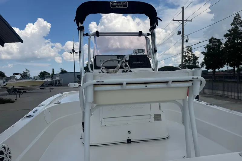 Slide: The Image of 2019 Epic E2 2100 Bay boat with console and seating, parked outdoors under cloudy sky. - 15