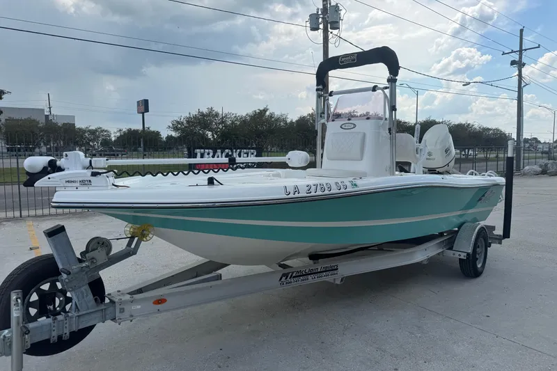 Slide: The Image of 2019 Epic E2 2100 Bay boat on trailer, parked outdoors under cloudy sky. - 7