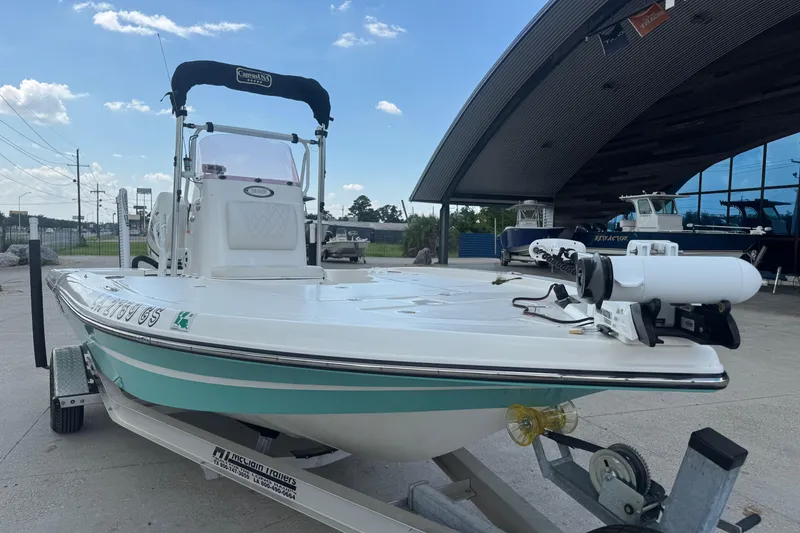 Slide: The Image of 2019 Epic E2 2100 Bay boat on trailer, parked outside a modern building. - 9