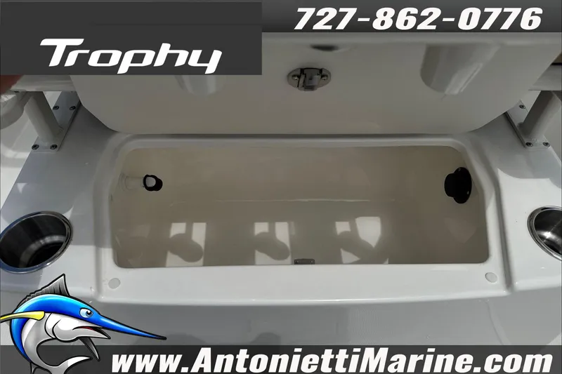 Slide: The Image of 2026 Trophy T22CC Center Console boat storage compartment, featuring cup holders and marine branding. - 17