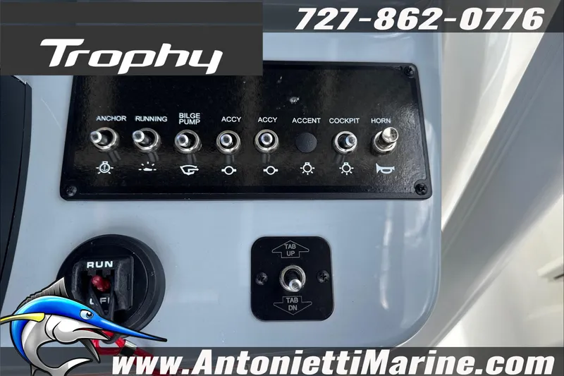 Slide: The Image of Control panel of 2026 Trophy T22CC Center Console boat with switches and branding. - 19