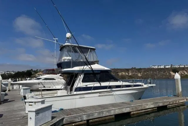 The Image of 1992 Mediterranean 38 Convertible yacht docked at marina under clear blue sky. - 1