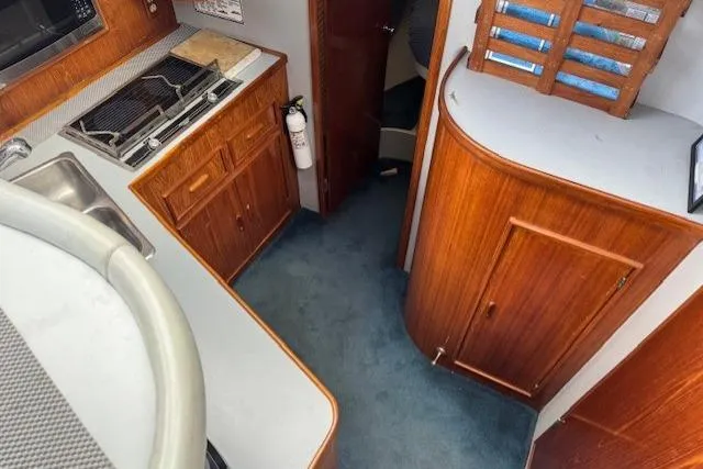 Slide: The Image of Interior of 1992 Mediterranean 38 Convertible yacht with wooden cabinetry and compact kitchen area. - 12