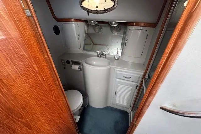 Slide: The Image of Bathroom interior of 1992 Mediterranean 38 Convertible yacht, featuring sink and toilet. - 14