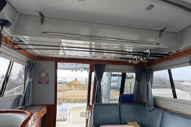 Slide: The Image of Interior of 1992 Mediterranean 38 Convertible yacht with blue seating and fishing rods. - 20