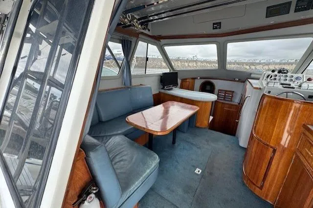 Slide: The Image of Interior of 1992 Mediterranean 38 Convertible yacht with wood accents and blue seating. - 21