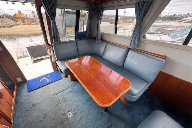 Slide: The Image of Interior of 1992 Mediterranean 38 Convertible yacht with blue seating and wooden table. - 24