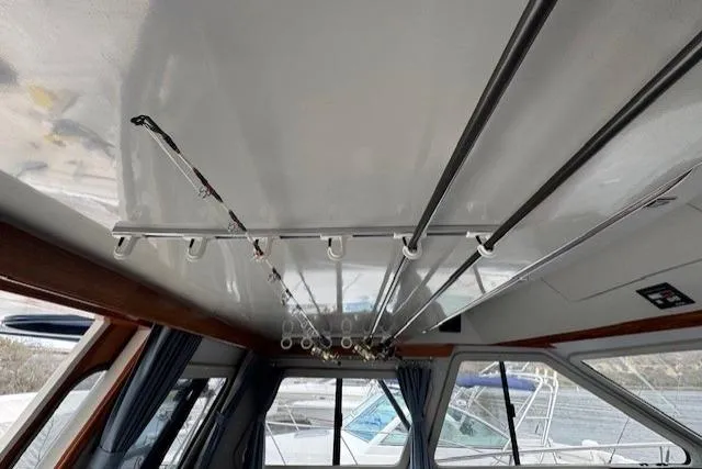 Slide: The Image of Interior view of a 1992 Mediterranean 38 Convertible boat with fishing rods on ceiling rack. - 29