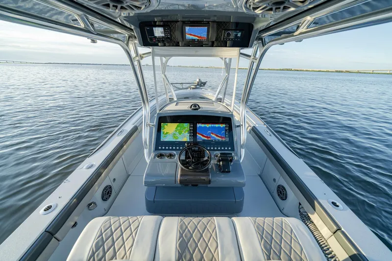 Slide: The Image of 2024 Valhalla Boatworks V-29 Hybrid dashboard with navigation screens on calm water. - 23