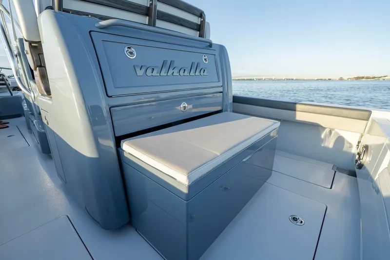 Slide: The Image of 2024 Valhalla Boatworks V-29 Hybrid interior with seating and storage, on calm water. - 29