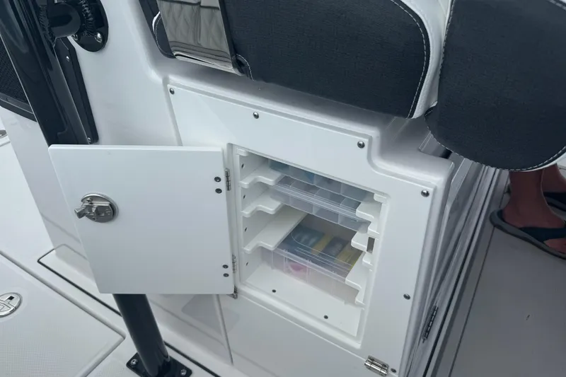 Slide: The Image of 2024 Blackfin 332 CC boat storage compartment with open door and organized shelves. - 12